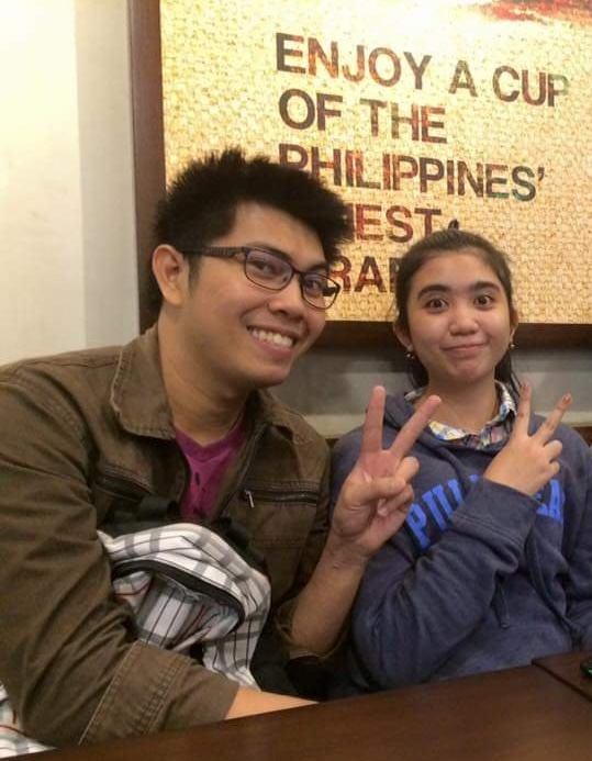Gerald and Edin flashing peace signs at a coffee shop