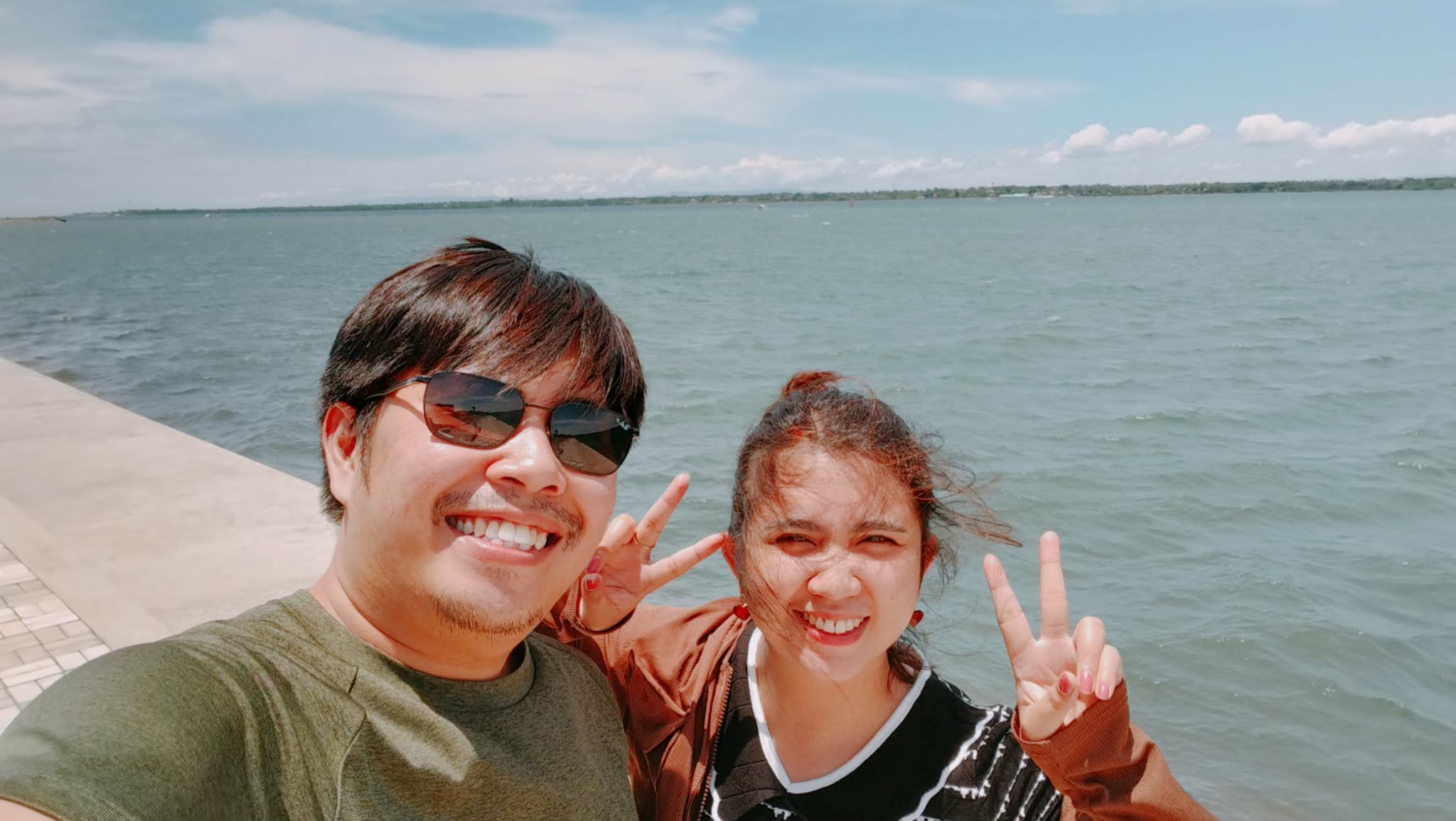 Gerald and Edin by the sea flashing peace signs
