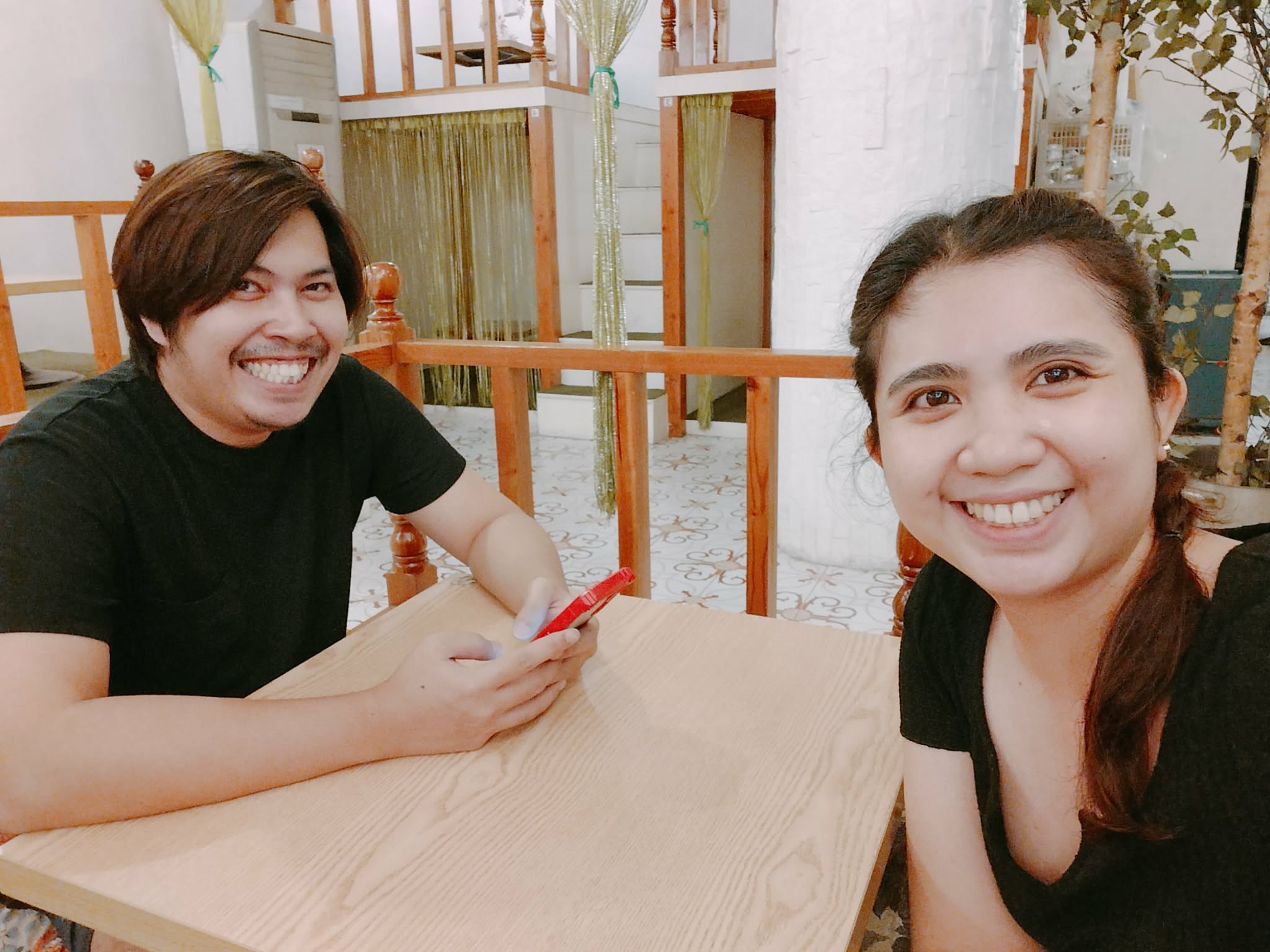 Gerald and Edin smiling at a cafe table