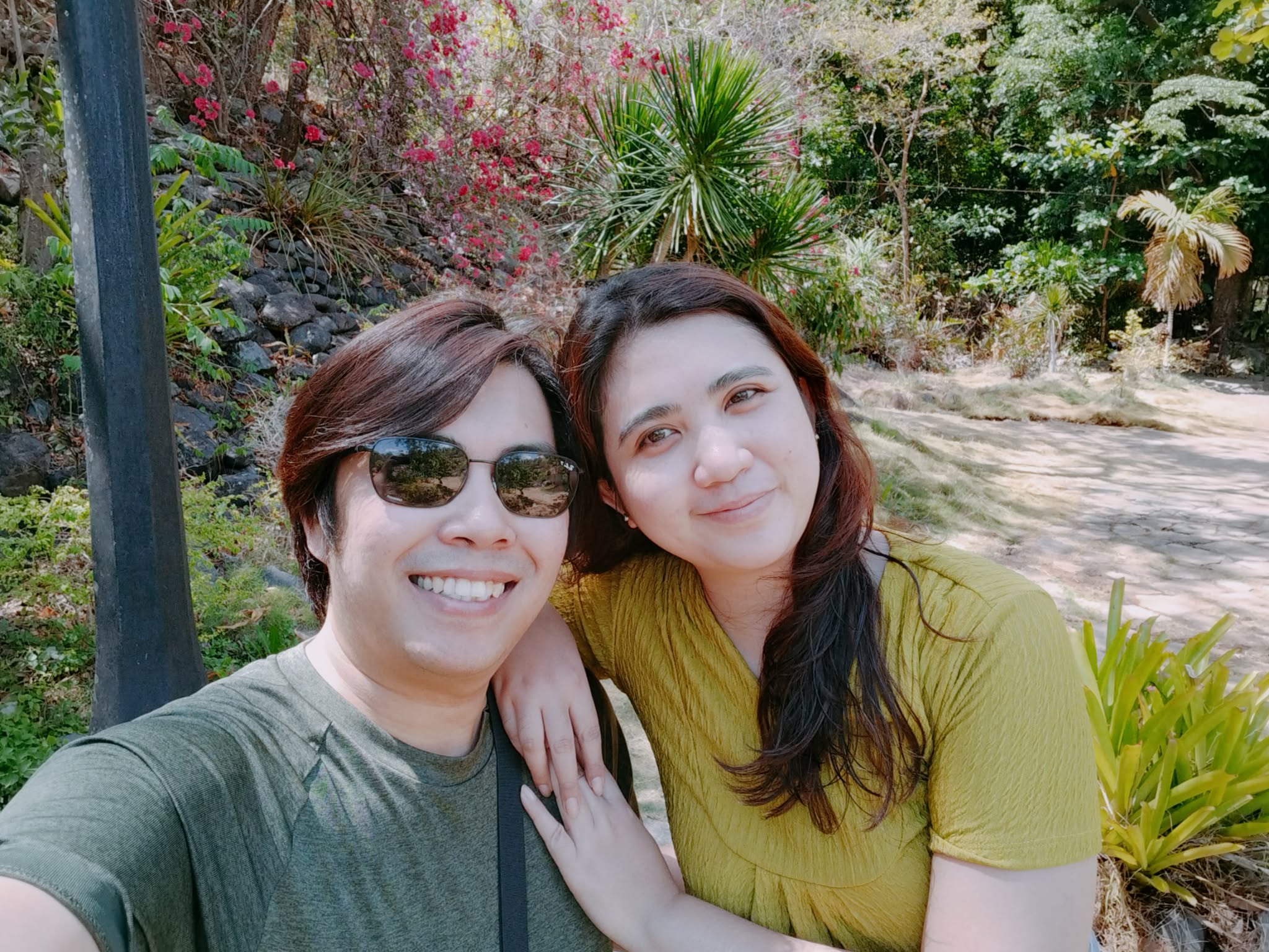 Gerald and Edin in a garden with bougainvillea
